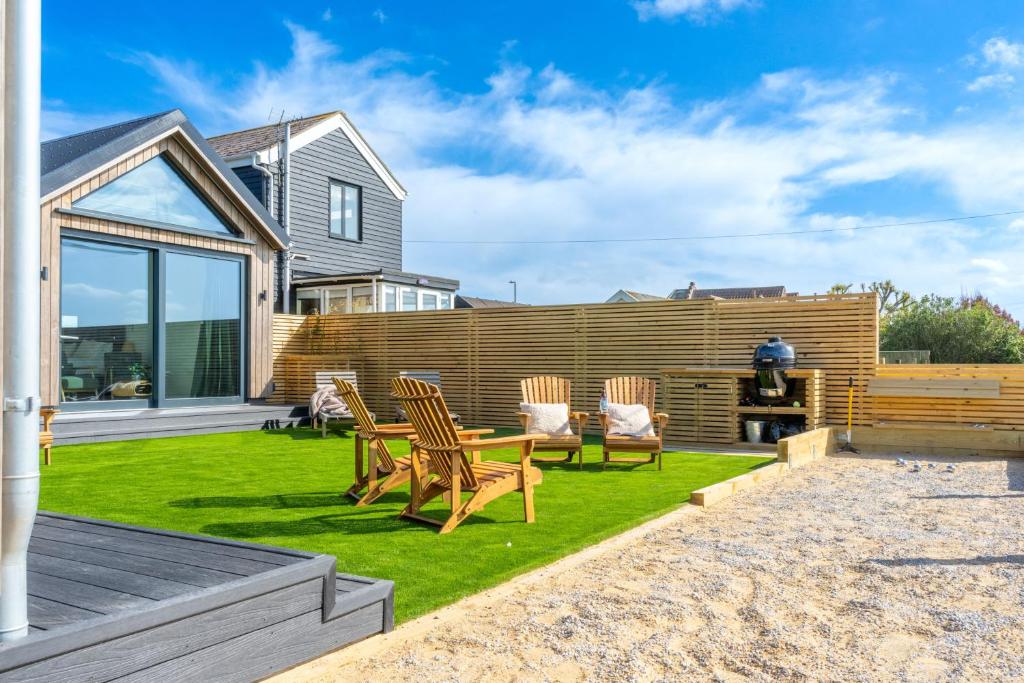a backyard with a table and chairs on the grass at The Ark 4 in Southwold