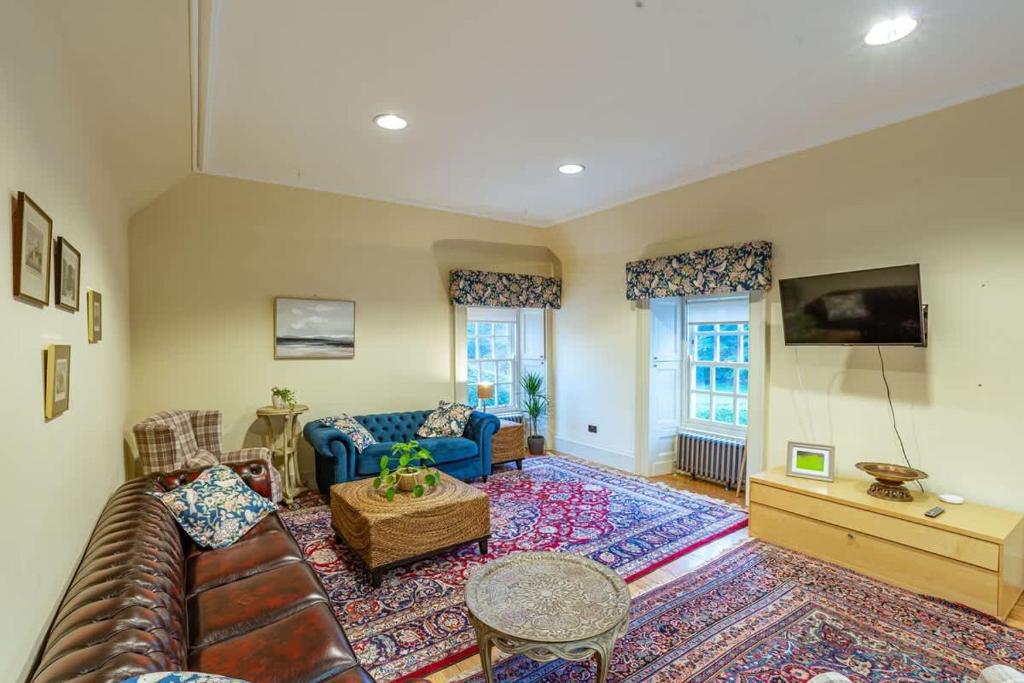 a living room with a couch and a table at Penninghame Estate - Stewart Apartment in Challoch