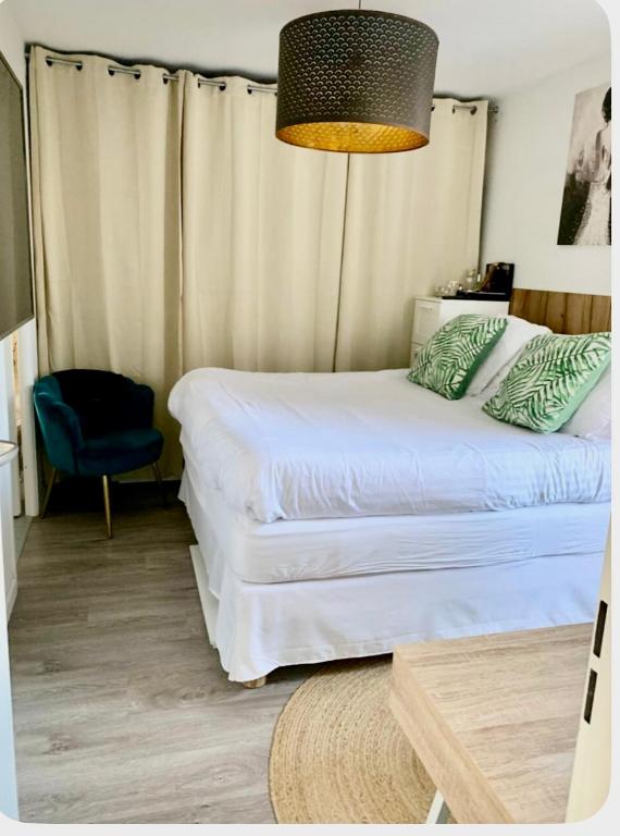 une chambre avec un lit blanc et une chaise bleue dans l'établissement Mendes seixas, à Villepinte