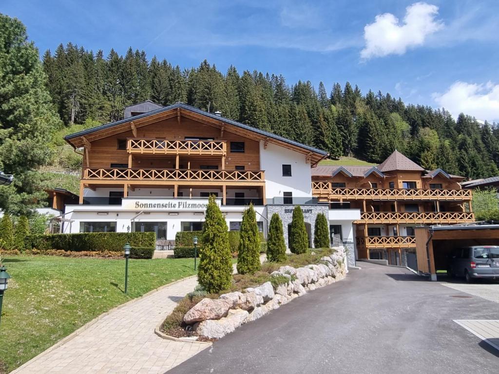 a large wooden house with a driveway at Sonnenseite Filzmoos in Filzmoos