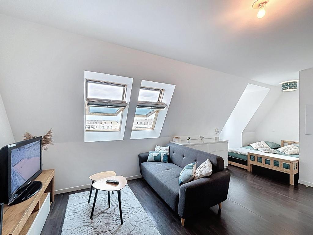 un salon avec un canapé et un lit dans l'établissement Pleasant Studio, à Saint-Brieuc