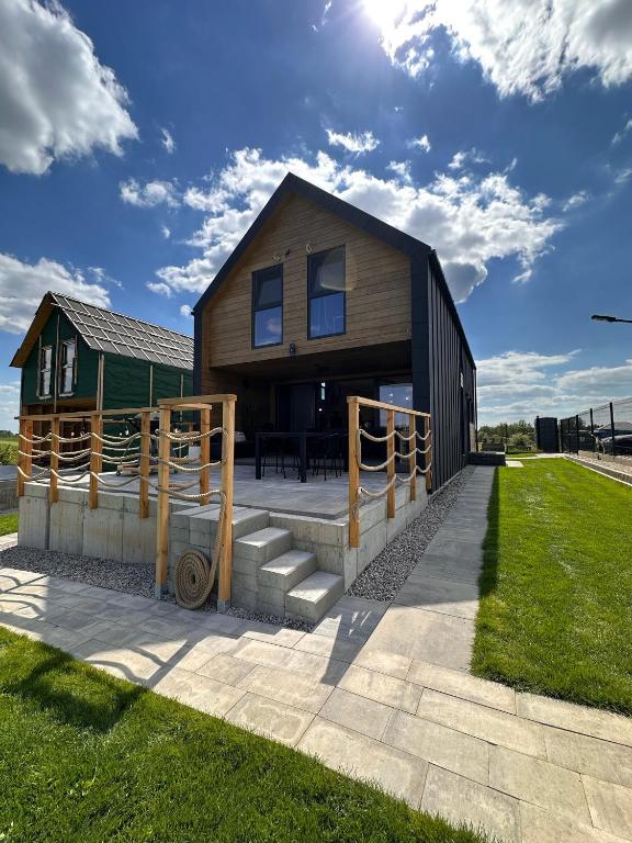 a wooden house with a patio and grass at Zacisze Mrozy in Ełk