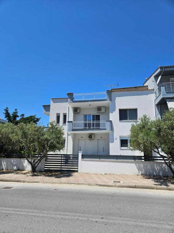 una casa blanca al costado de una calle en Nias Apartments 103, en Keramotí