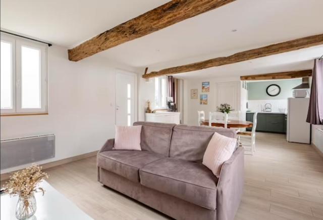 un salon avec un canapé et une cuisine dans l'établissement TCHOMe, à La Celle-sous-Gouzon