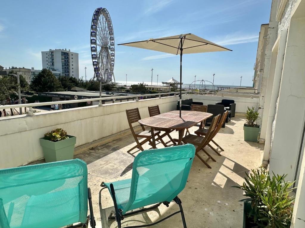 une table et des chaises avec un parasol sur le toit dans l'établissement SEA VIEW terrace and garage in Berck-Plage, à Berck-sur-Mer