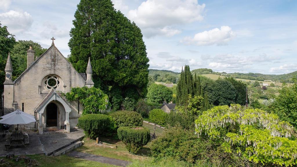 an old church with an umbrella in a garden at The Old Chapel in Painswick