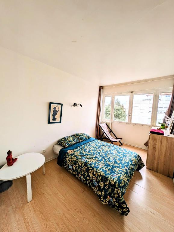 a bedroom with a bed and a table in it at Anglet, Chambre chez l'habitant in Anglet