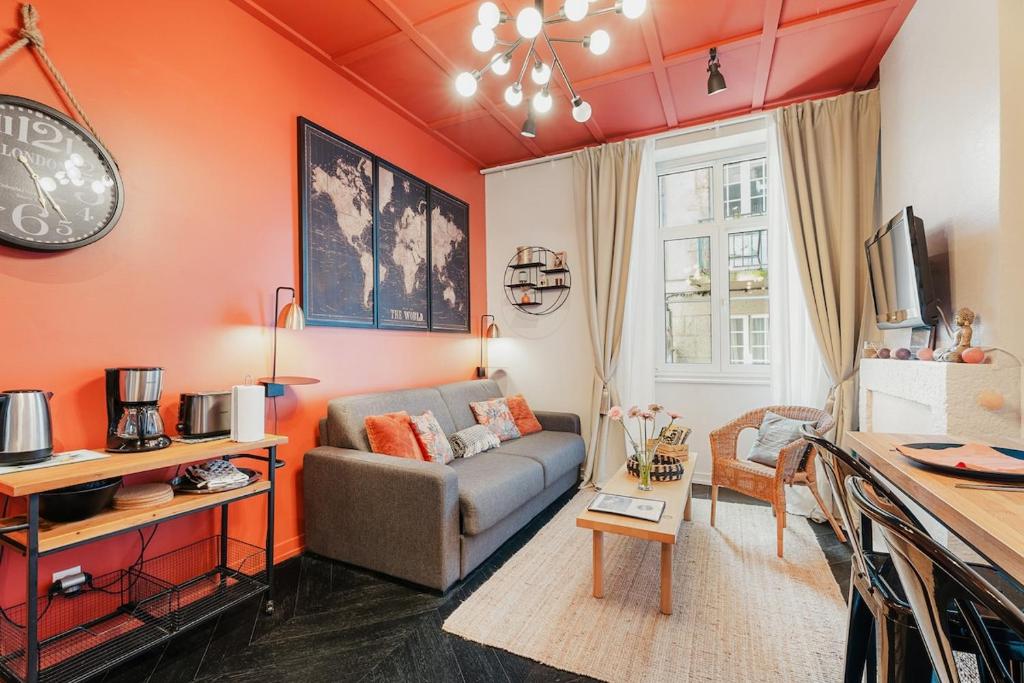 - un salon avec des murs orange et un canapé dans l'établissement L'Orange Malouine - Studio 2 people with WiFi, à Saint-Malo