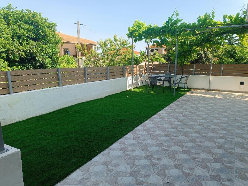 a patio with a table and green grass at Holiday Home Klimataria in Áyios Pétros