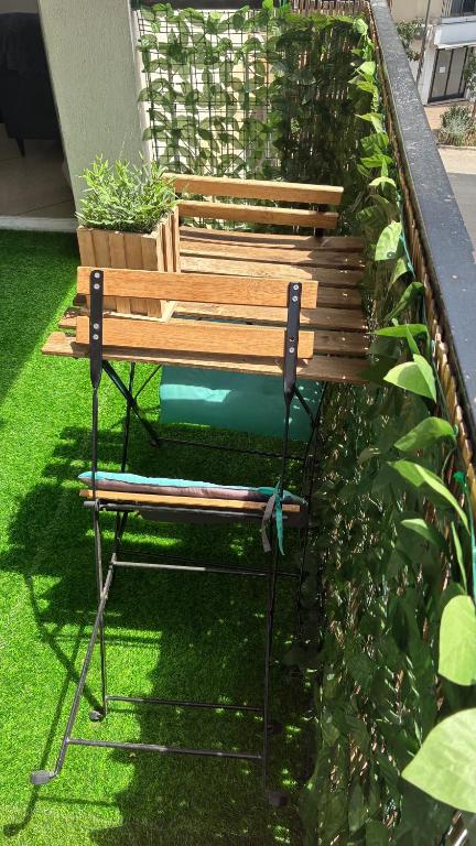 un banc installé sur l'herbe dans un jardin dans l'établissement Nice Séjour Detente Studio Lumineux Balcon Cuisine Equipée Wifi, à Nice