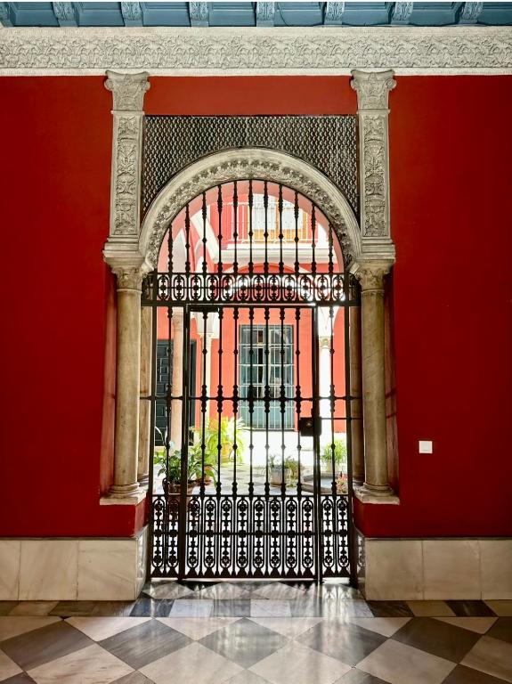 żelazna brama w budynku z czerwonymi ścianami w obiekcie Casa Palacio Doña Guiomar w Sewilli