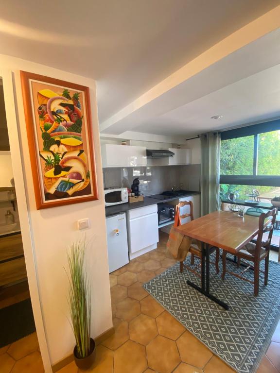 Il comprend une cuisine et une salle à manger avec une table en bois. dans l'établissement Entre Mer et Montagne, à Toulouges