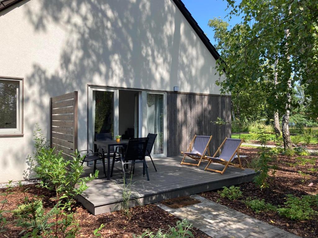 姆热日诺Apartamenty Słoneczna 18 Mrzeżyno的一间小房子，露台上有一张桌子和几把椅子