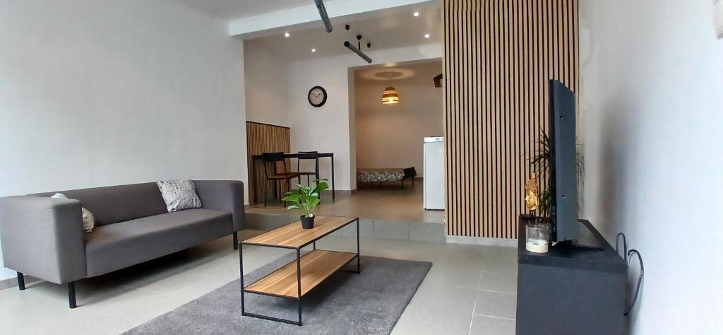 a living room with a couch and a table at studio dans le centre de Mons in Mons