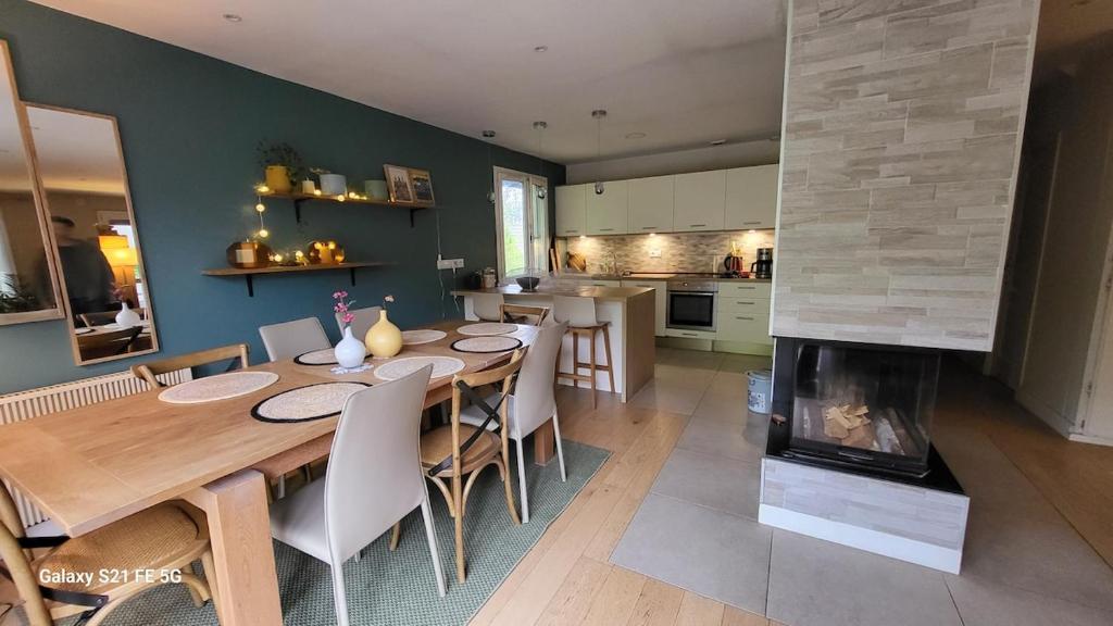 une salle à manger avec une table et une cheminée dans l'établissement Au pied de la Chartreuse, à Saint Bernard du Touvet
