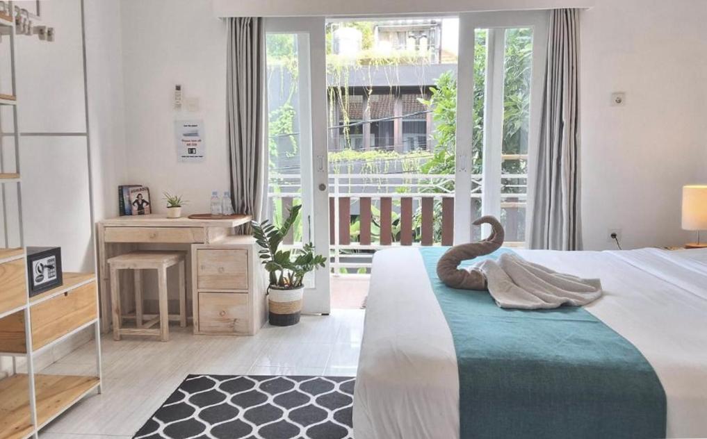 ein Schlafzimmer mit Bett, Schreibtisch und Fenster in der Unterkunft The shortcut rooms in Canggu