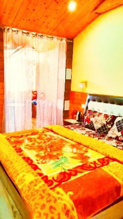 a bedroom with a bed with a giraffe blanket at Ridge Lakkar Stay in Shimla