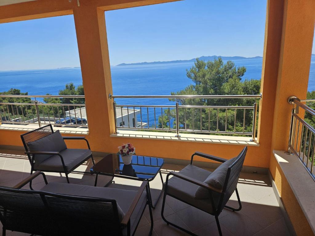 a balcony with chairs and tables and a view of the ocean at Apartments Martina in Prizba