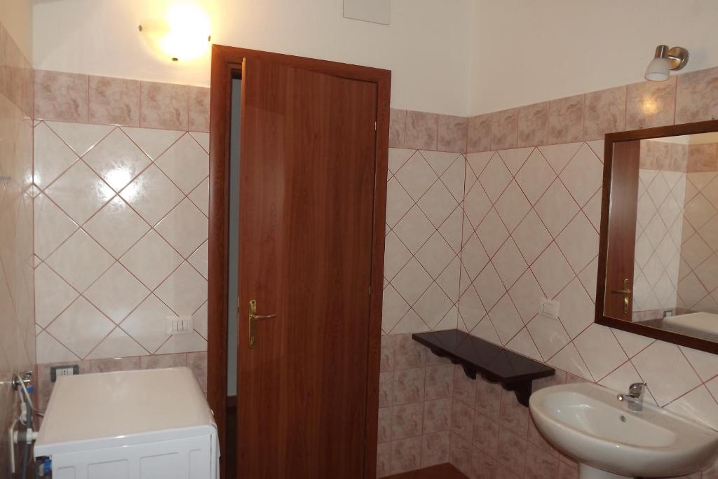 a bathroom with a sink and a toilet and a mirror at Yellon House in Santa Maria Navarrese