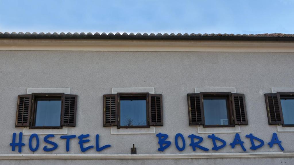 a hospital sign on the side of a building with windows at Hostel Bordada in Kraljevica