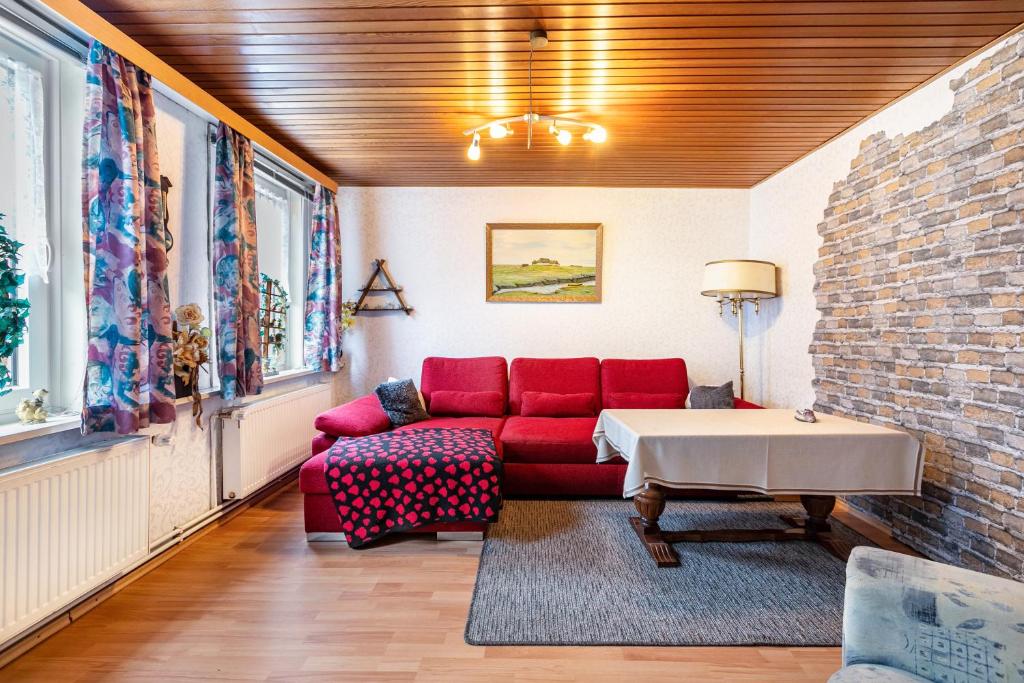 a living room with a red couch and a table at Altstadt Ferienhaus mit Terrasse in Husum
