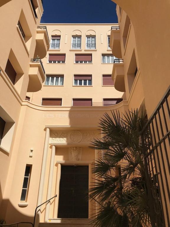 un grand bâtiment avec un palmier devant lui dans l'établissement Toulon T2 4 couchages, à Toulon