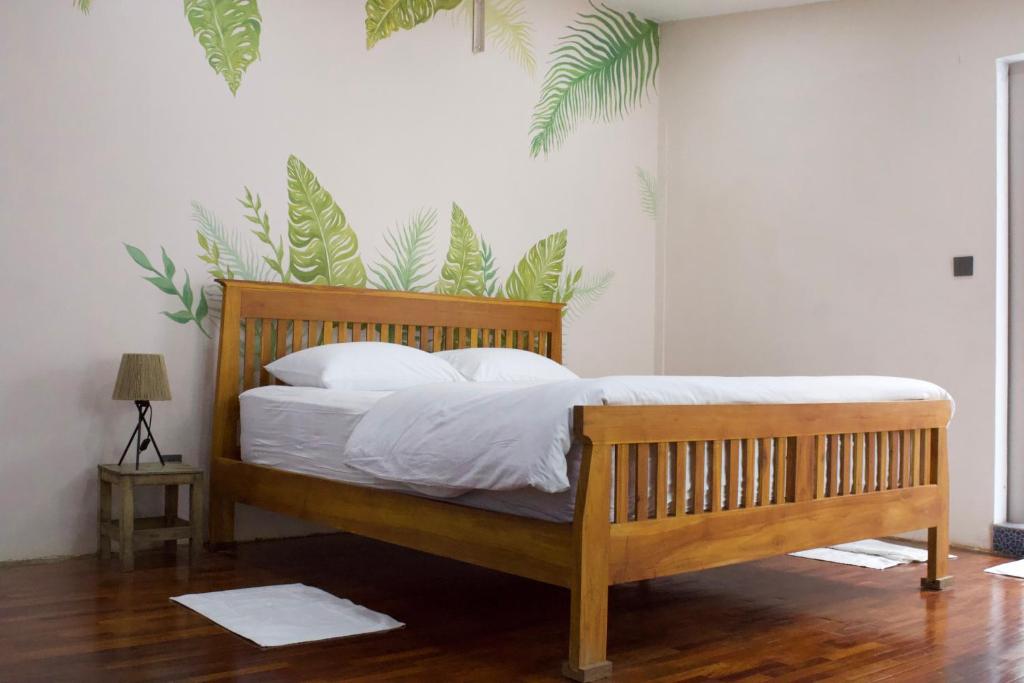 - un lit en bois avec des draps et des oreillers blancs dans une chambre dans l'établissement Urban Oasis Studio with Bathtub & Garden - Vientiane Centre, à Vientiane