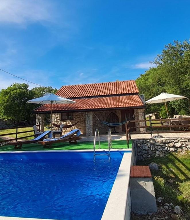 a swimming pool in front of a house at Agroturizam Villa Antonija in Neum