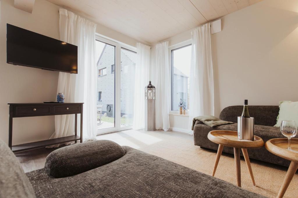 a living room with a couch and a tv at "Rügen Resort Sagard" großzügige, gemütliche Doppelhaushälfte "Bente" mit Terrasse in Sagard
