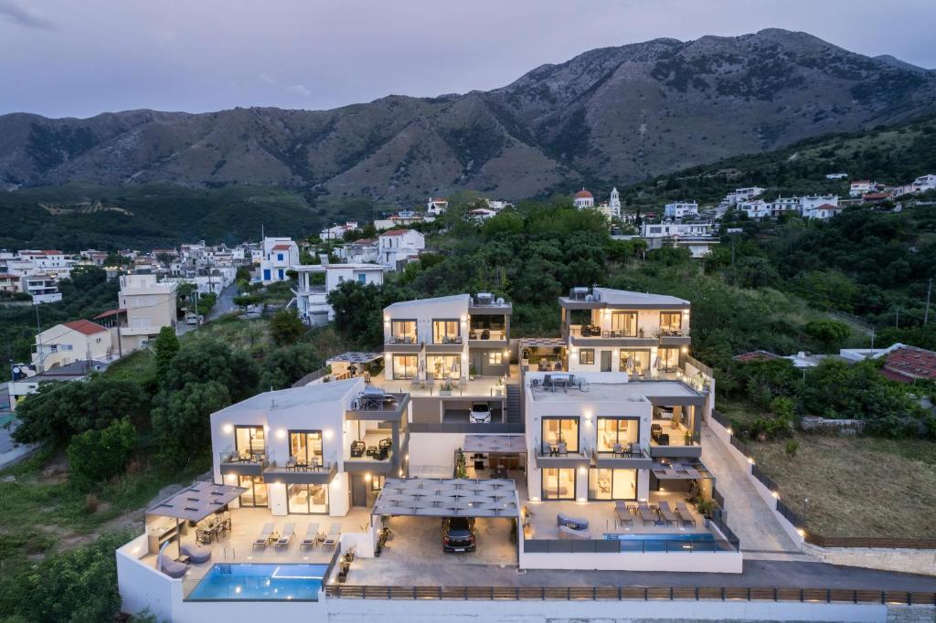 a large white house with a mountain in the background at Four Horizons Luxury Villas in Kournás