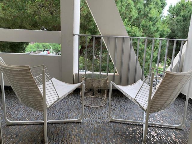 deux chaises et une table sur un balcon dans l'établissement Clinfoc 21, à La Grande Motte