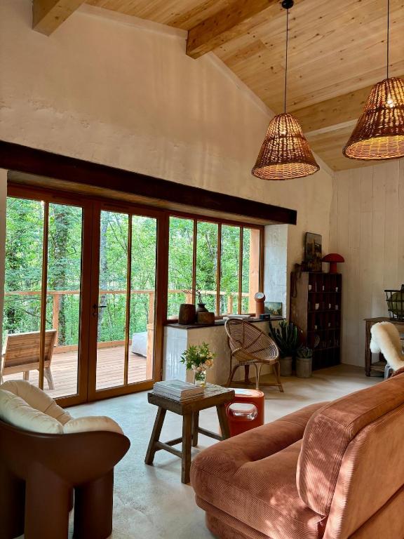 un salon avec un canapé et une table dans l'établissement La cabane dans les arbres, à Couze-et-Saint-Front