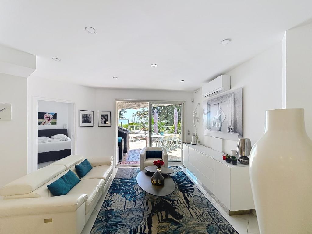 un salon blanc avec un canapé et une table dans l'établissement Apartment La Palmeraie with terrace Golfe Juan, à Vallauris