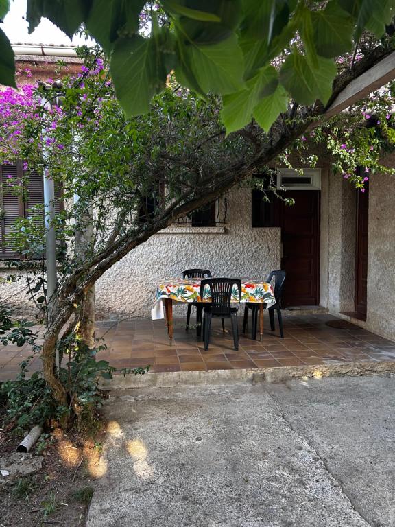 une table et des chaises assises sur une terrasse dans l'établissement Maison familiale mer et montagne, à Santa-Lucia-di-Moriani