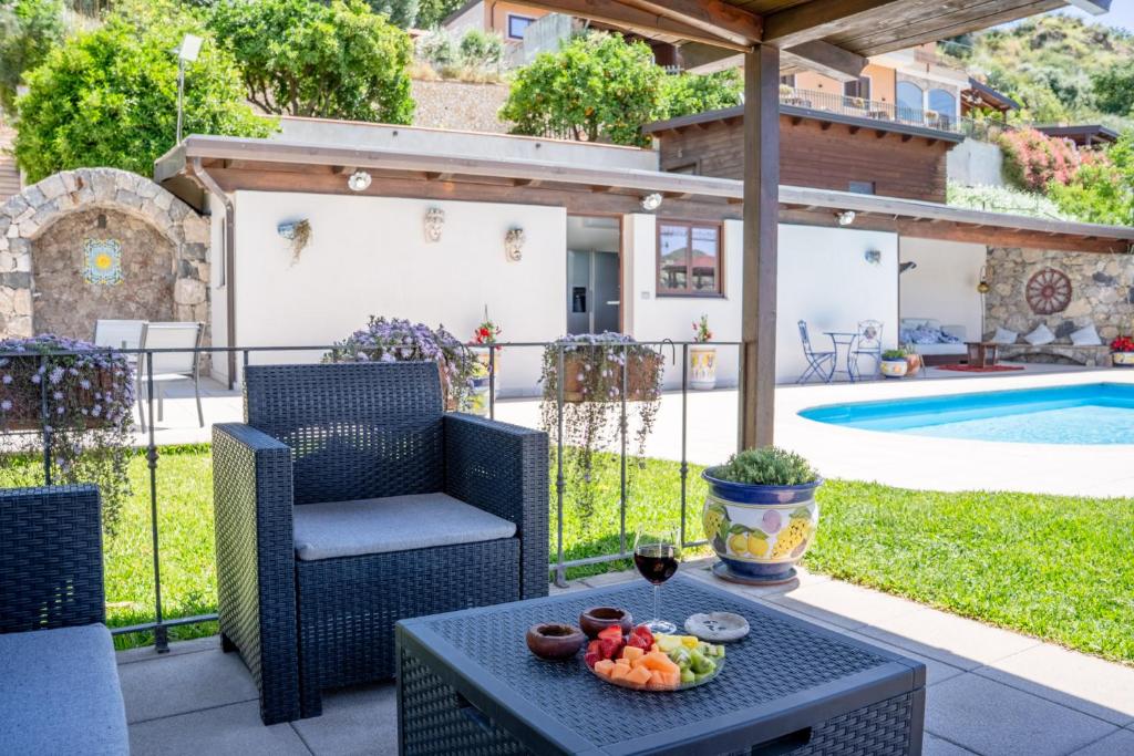 a patio with a table and chairs and a pool at Villa Agave Pool & Spa in Gaggi