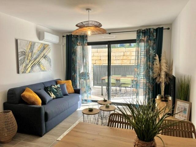 un salon avec un canapé bleu et une table dans l'établissement T2 confort - résidence privée, à Propriano