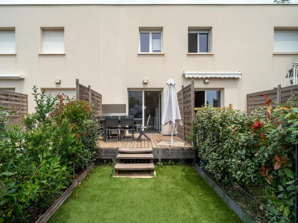 un jardin avec une pelouse devant un bâtiment dans l'établissement La Dune N52 - Villa 3P6, à Sérignan