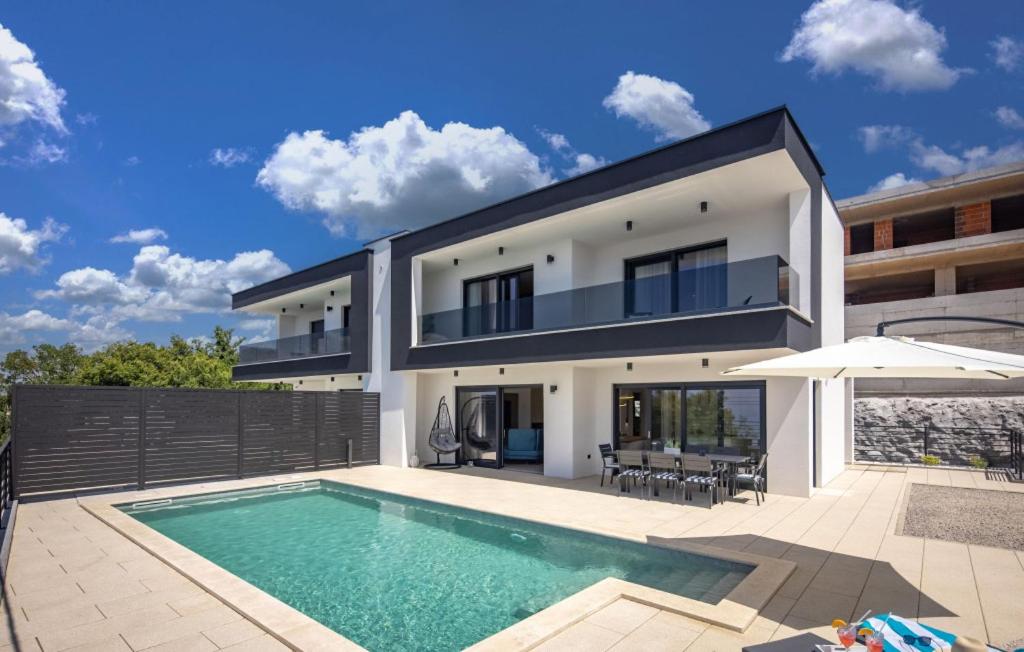 a house with a swimming pool in front of it at Villa Aura by Villas Guide in Urinj