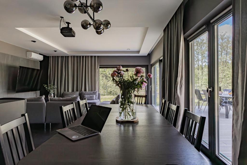 a dining room table with a laptop on top of it at Ostoja Rekownica - Sauna & Balia - Kaszuby in Będomin