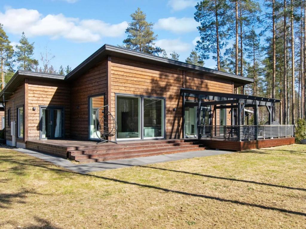 une maison en rondins avec un grand porche et une terrasse dans l'établissement Holiday Home Villa dalton by Interhome, à Vierumäki