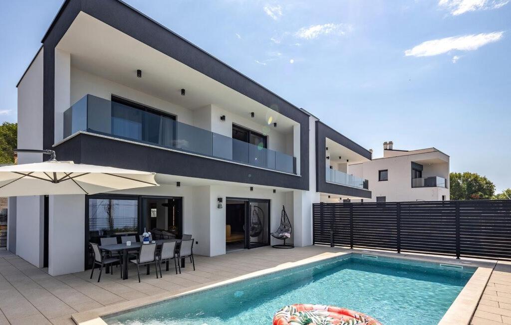 a villa with a swimming pool and a house at Villa Aris by Villas Guide in Urinj