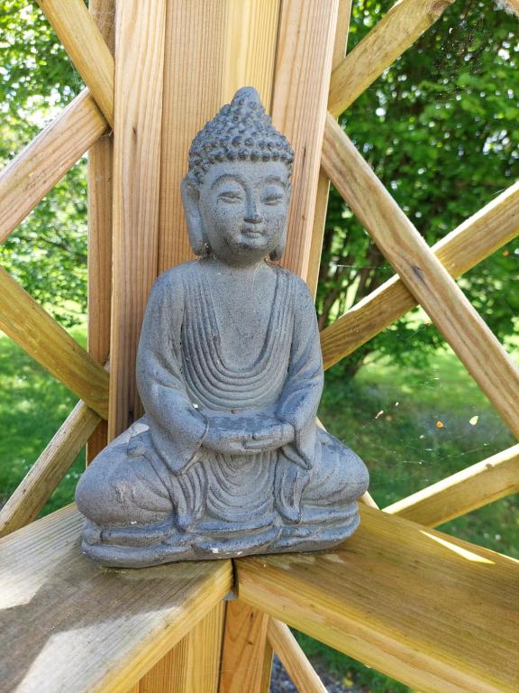 une statue en pierre assise sur une structure en bois dans l'établissement La Cressonnière 56, à Missiriac