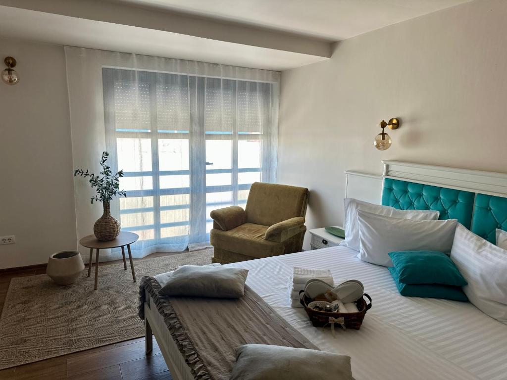 a bedroom with a large bed and a chair at La Vista by Ronda in Eforie Sud