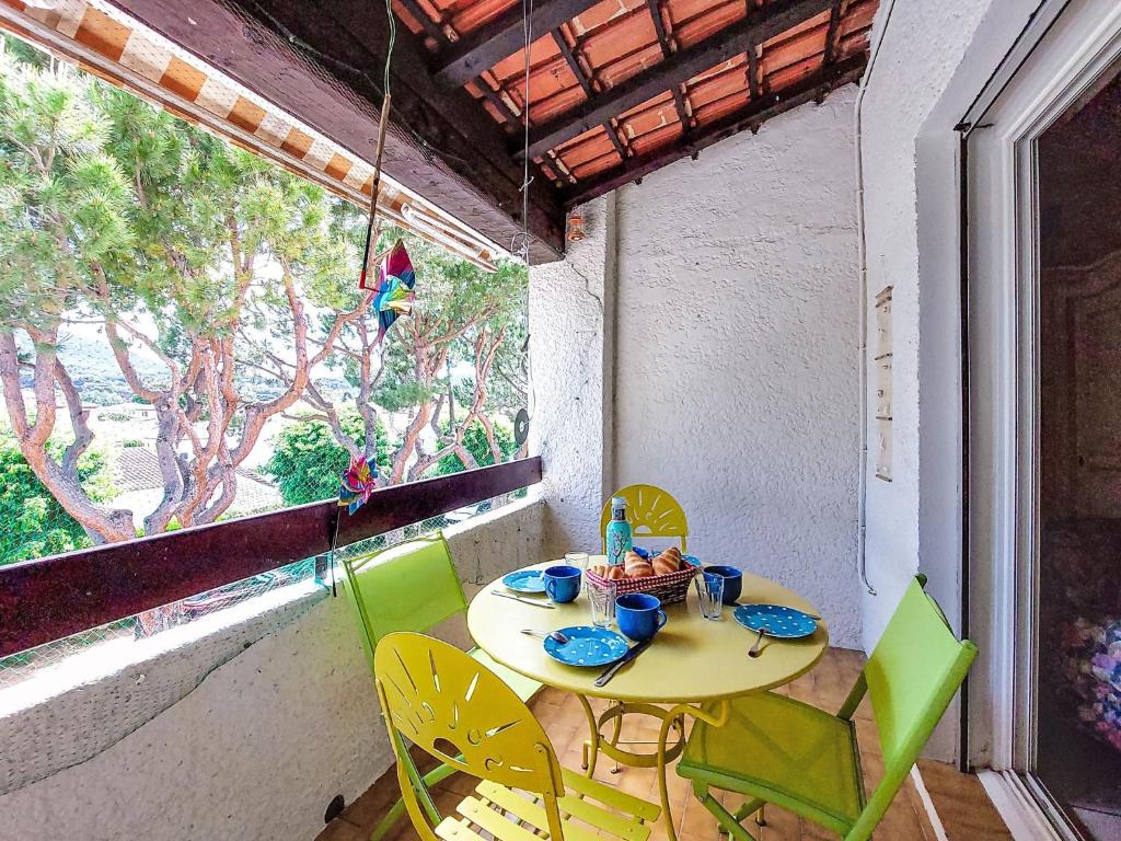 une table et des chaises dans une pièce avec une fenêtre dans l'établissement Apartment L'Ile heureuse-9 by Interhome, à Saint-Cyr-sur-Mer