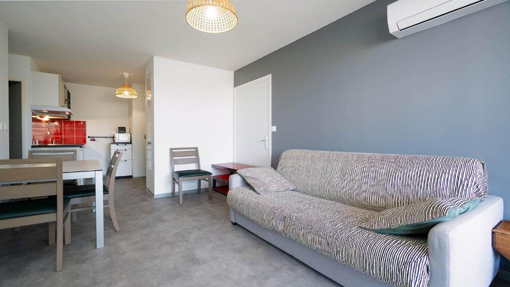 un salon avec un canapé et une table et une cuisine dans l'établissement La Dune B N204 - 2P4, à Sérignan