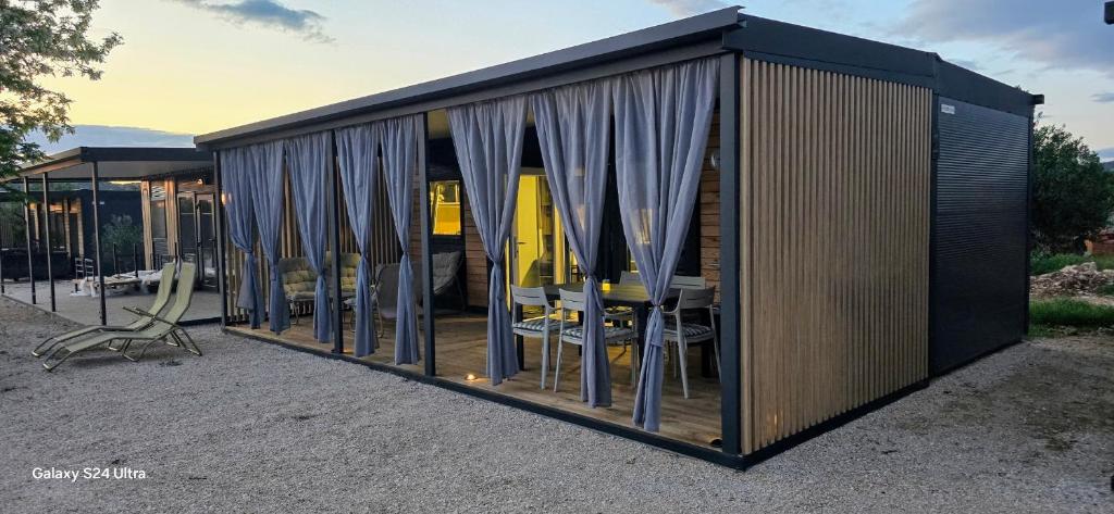 a building with a table and chairs in it at Sak Mobile Home Pirovac III in Pirovac