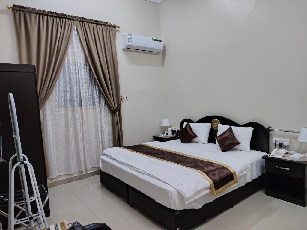 a bedroom with a large bed and a window at العييري للشقق المخدومة النعيرية 1 in Al Nairyah