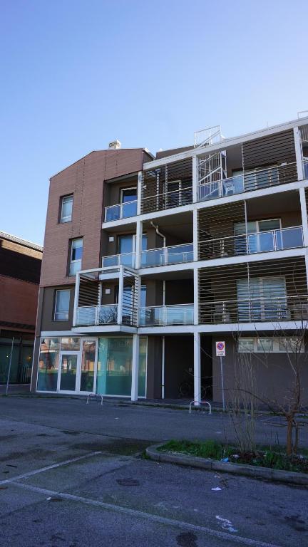 un parcheggio vuoto di fronte a un edificio di Casa Delfina a Marina di Ravenna