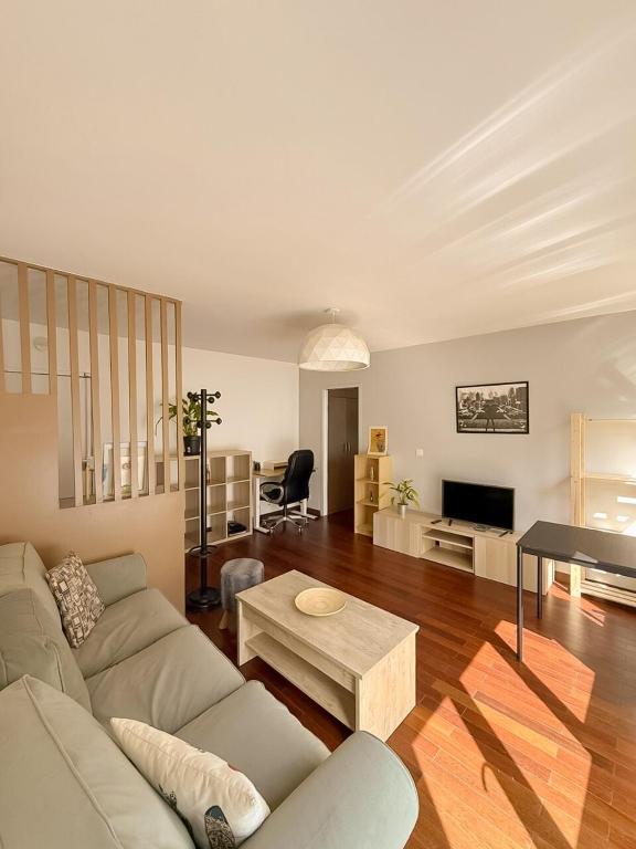 un salon avec un canapé et une table dans l'établissement Charmant 2P à Montrouge Wi-Fi & confort, à Montrouge