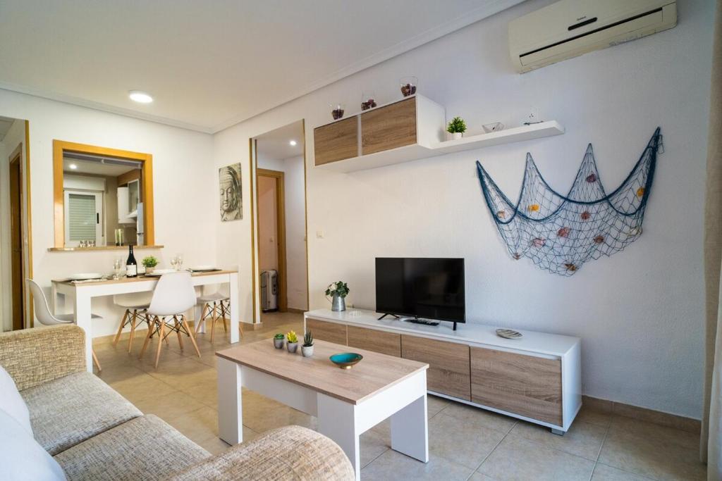 a living room with a couch and a tv and a table at Apartamento en Magic World in Oropesa del Mar